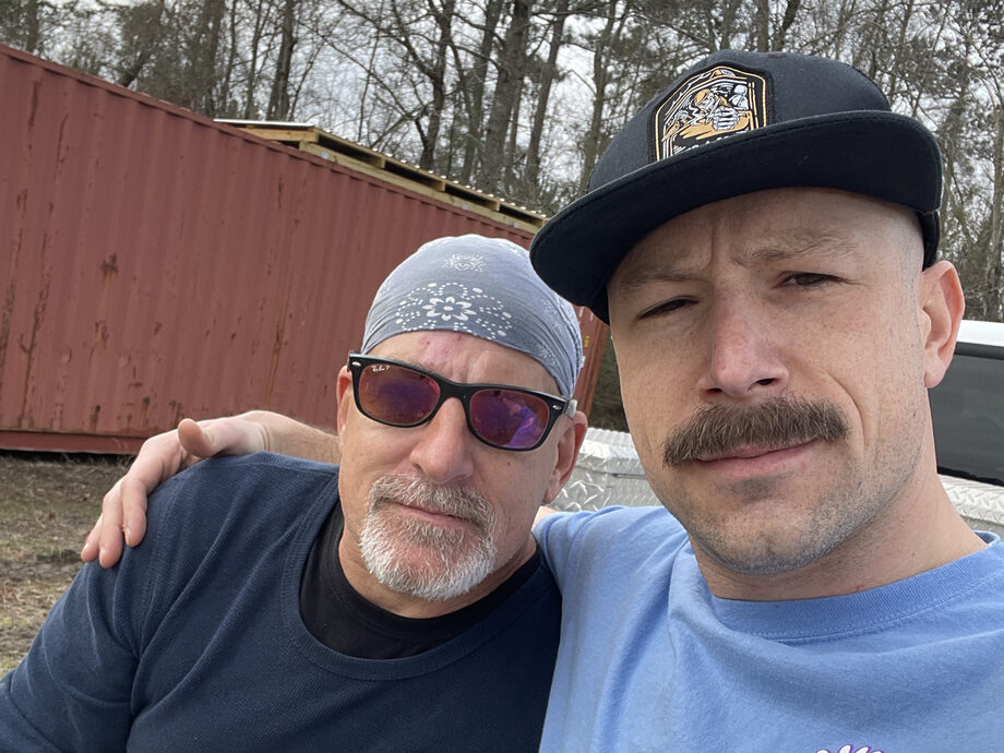 Kyle and his dad on the farm, a shipping container behind them